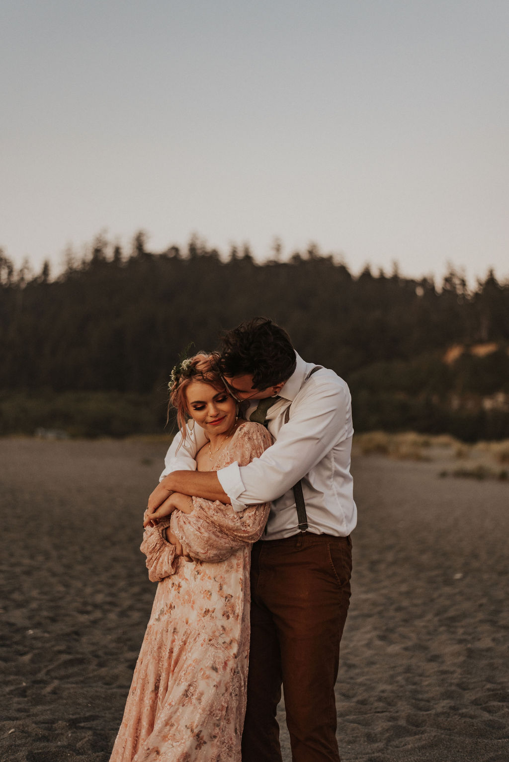 groom holding bride from behind photo at this beach elopement