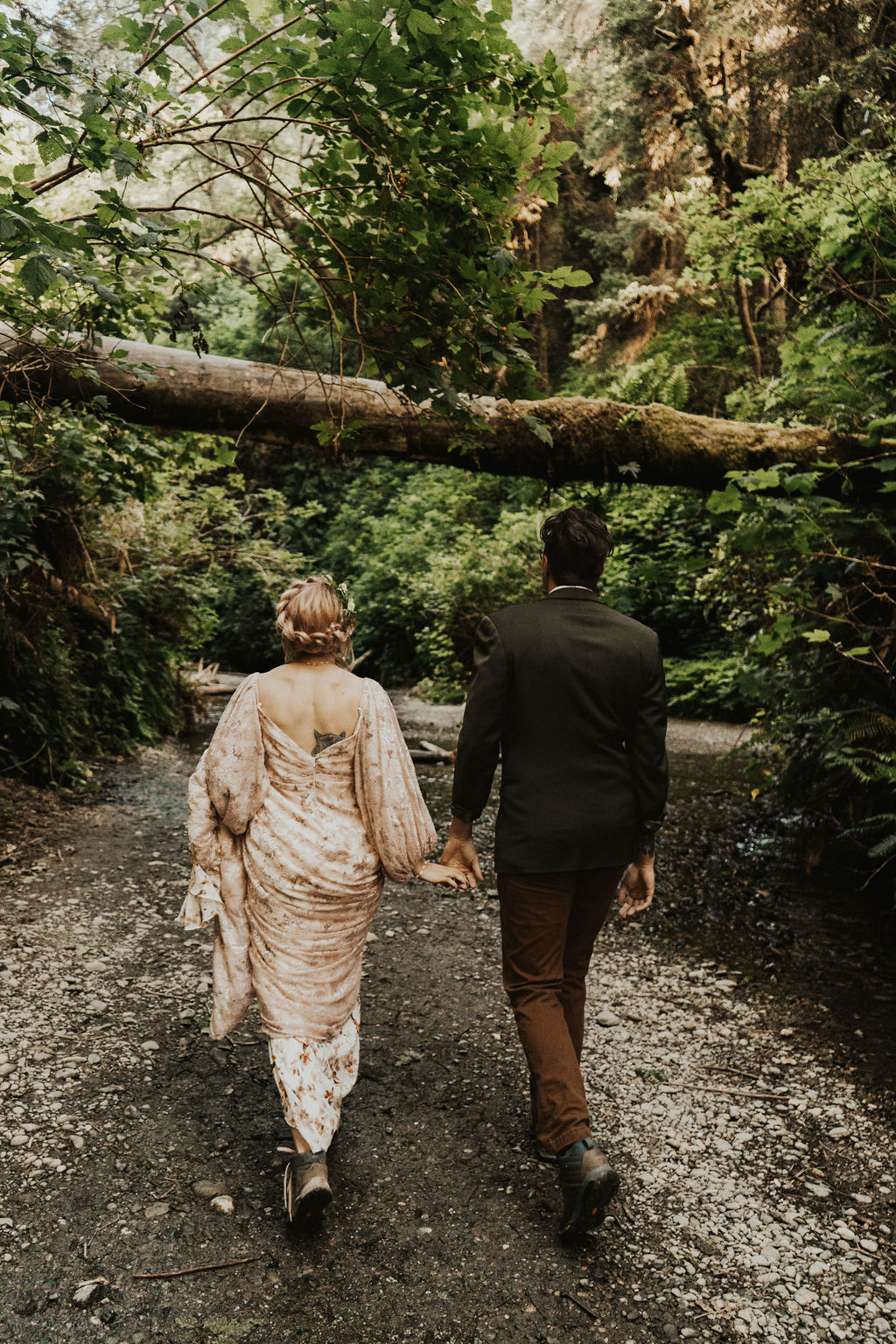bride and groom holding hands pose at their forest elopement 