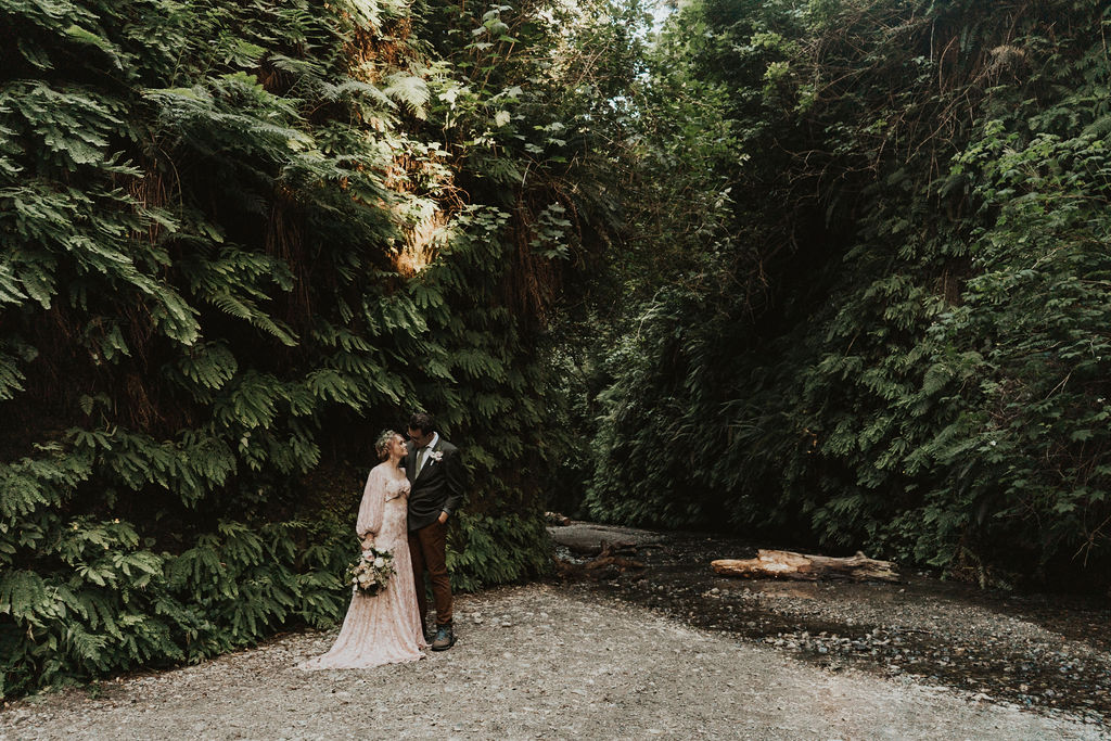 bride and groom look at each other in  this elopement photo at their forest elopement 