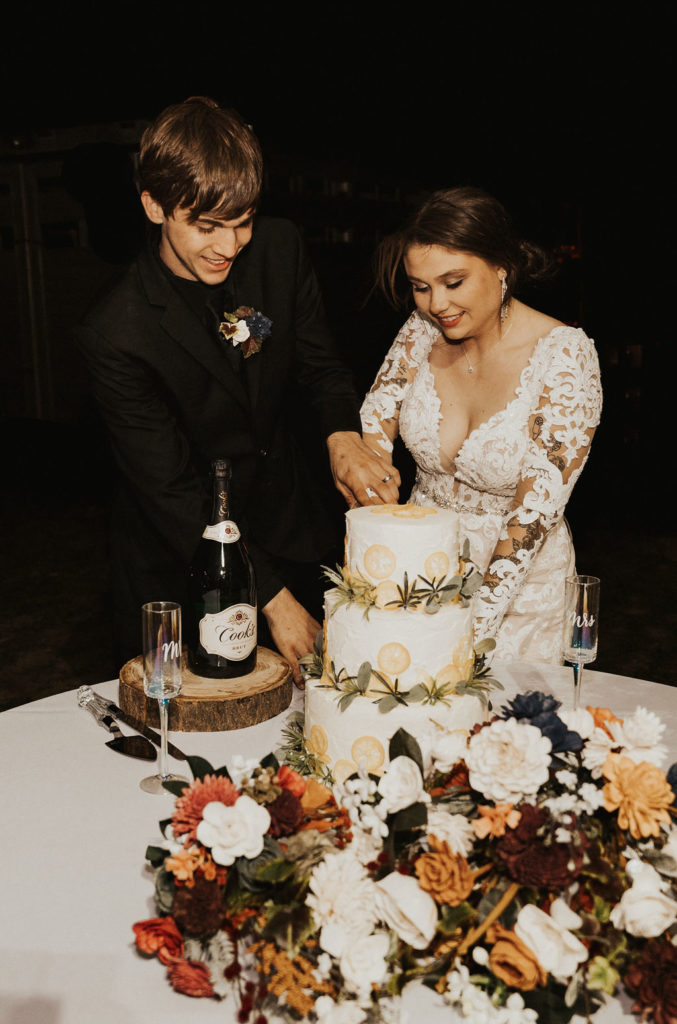 bride and groom cutting into their wedding cake