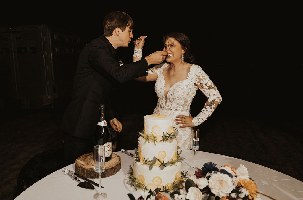 bride and groom feed each other wedding cake 