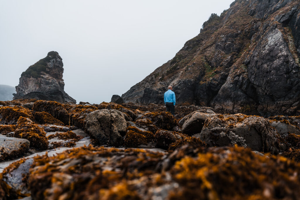 groom. standing amongst tidepools in Oregon