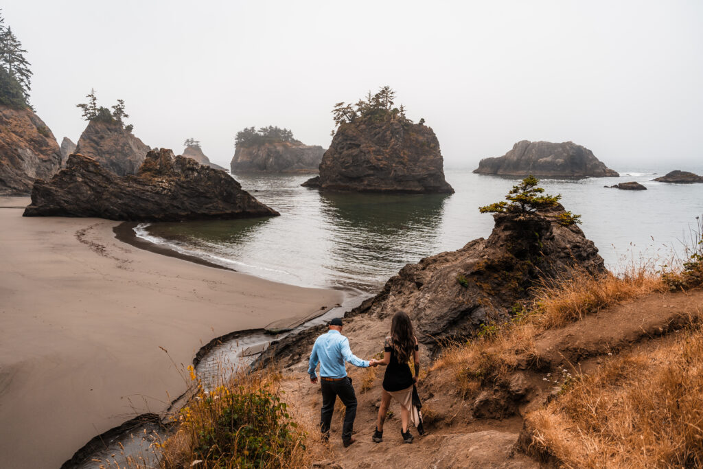 couple hiking down to a scenic beach in Oregon