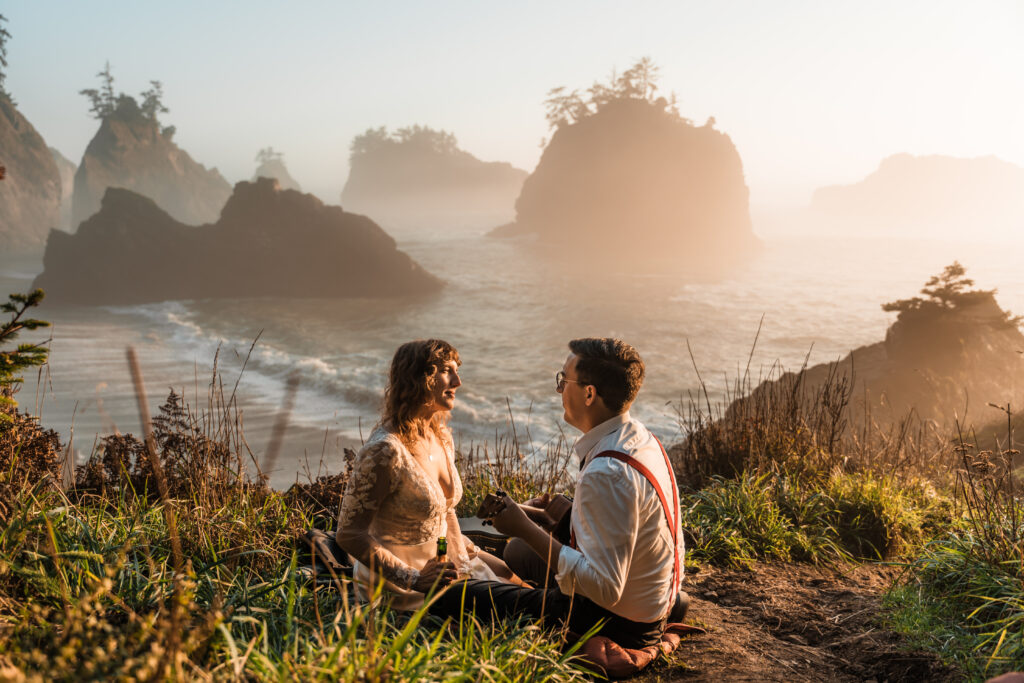 couple looking into each other's eyes while playing the guitar overlooking the ocean.