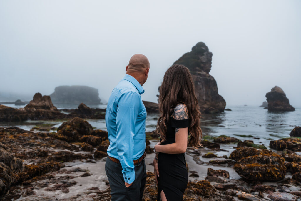 couple looking at a foggy morning over tidepools and the ocean