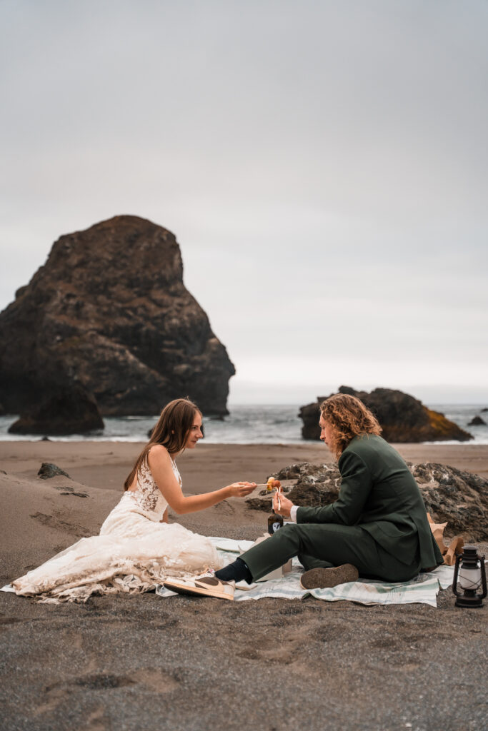 couple sharing a sushi picnic on a remote beach