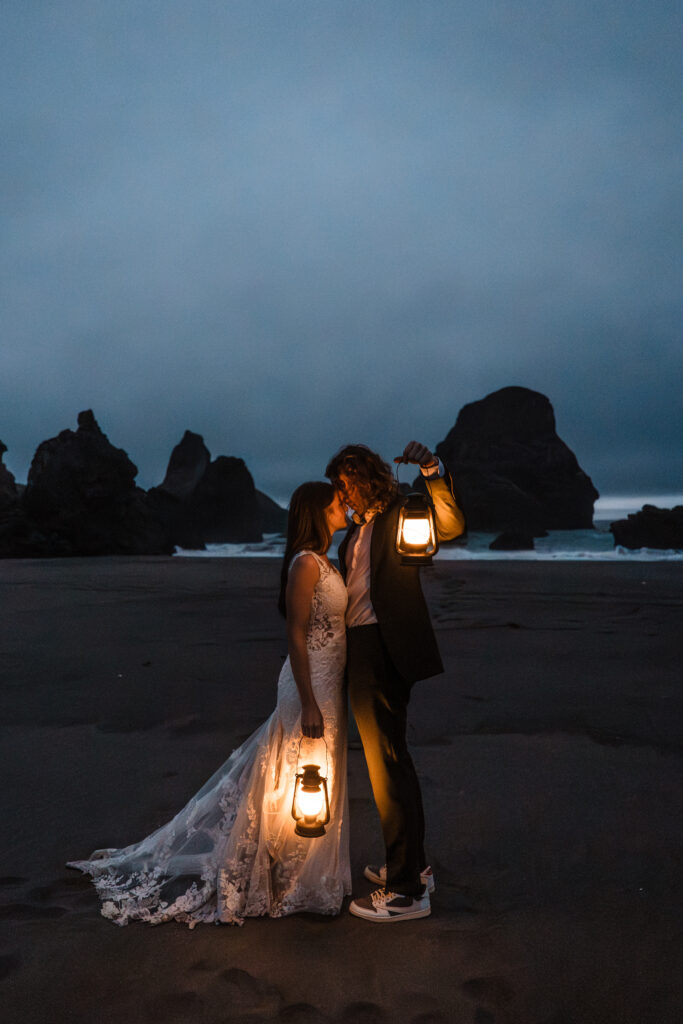 couple holding lanterns on the beach at night